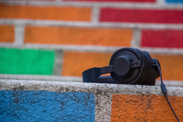 Headphones on a coloured brick wall